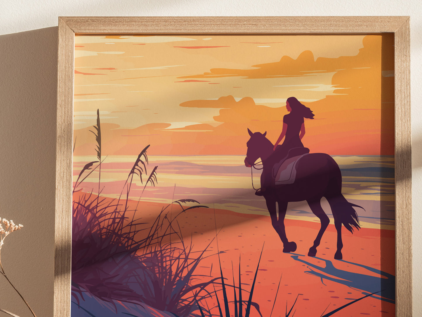 A framed artwork depicts a woman riding a horse along a beach at sunset, with sea oats and golden hues creating a serene atmosphere.