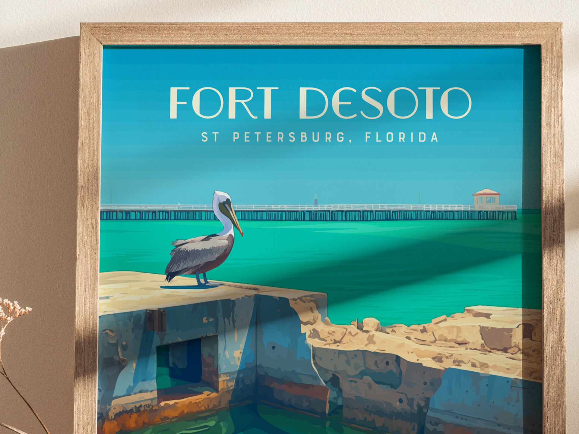 Illustrated poster of Fort Desoto, St. Petersburg, Florida, featuring a pelican on weathered fort ruins with turquoise water and a pier in the background. Framed with a wooden border.