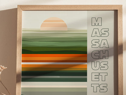 A framed poster with abstract green and orange horizontal stripes and a stylized sun, featuring the word MASSACHUSETTS vertically on the right side.