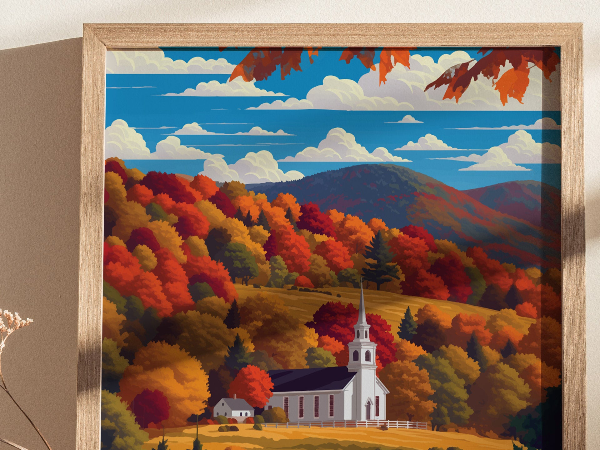 A framed artwork depicts a white church steeple amidst vibrant autumn foliage in red, orange, and gold, with rolling hills and a blue sky in the background.