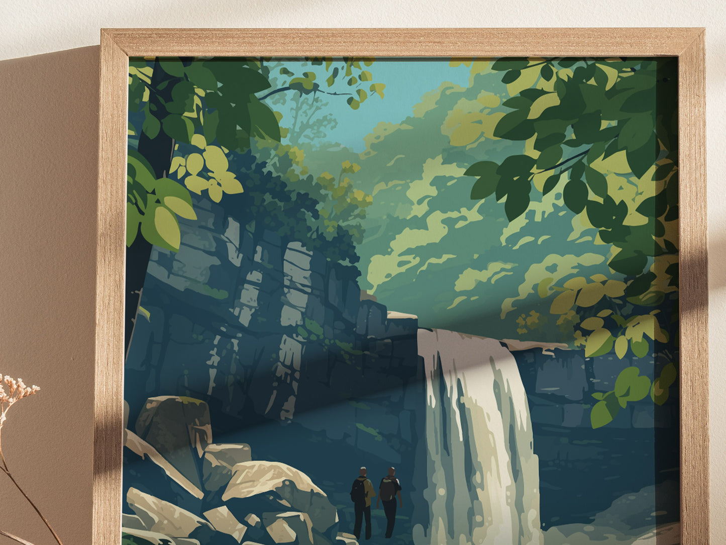 The image shows a framed poster depicting a serene waterfall cascading over rocks, surrounded by lush green foliage. Two figures stand at the base, adding a sense of scale to the tranquil natural scene.