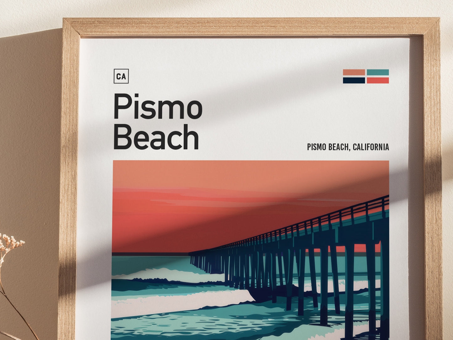 Framed Pismo Beach poster featuring a stylized pier silhouette against a vibrant red and blue sunset backdrop. The artwork includes bold text reading Pismo Beach, California and minimalist design elements.