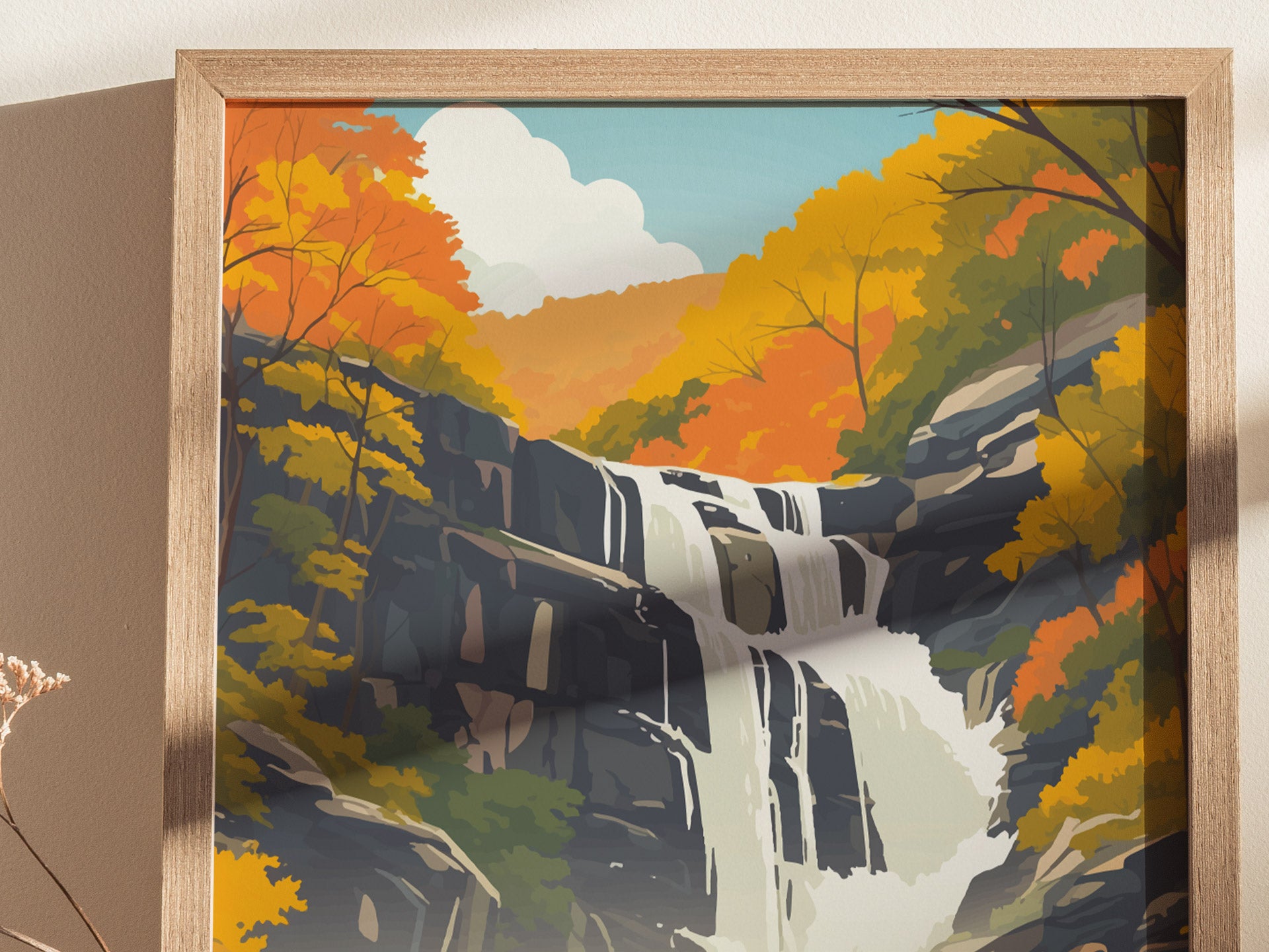 A framed poster depicting a cascading waterfall surrounded by vibrant autumn foliage in shades of orange and yellow, with a clear blue sky in the background.