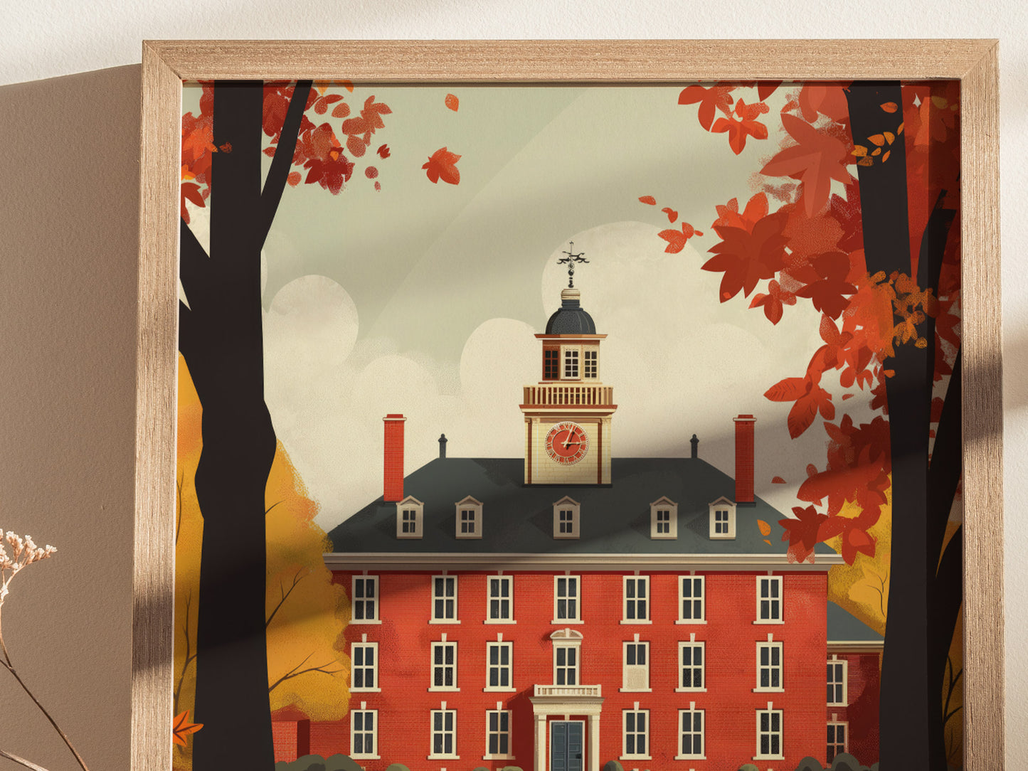 Illustrated poster of a red brick building with a clock tower, surrounded by autumn trees with red and orange leaves, framed in light wood.
