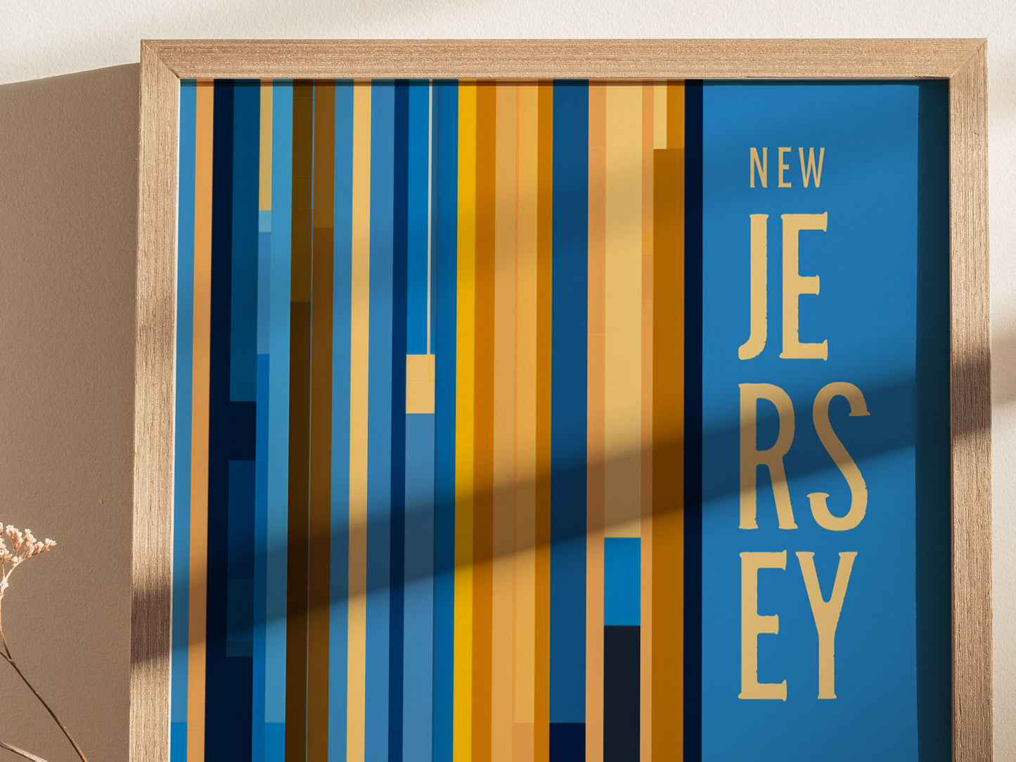 A New Jersey poster features vertical stripes in shades of blue, orange, and yellow with the text New Jersey in bold. A wooden frame surrounds the artwork.