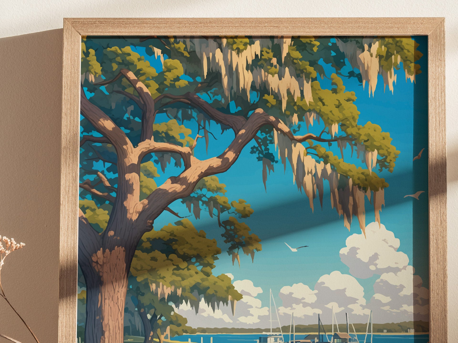 A framed art print depicting a Southern live oak tree with Spanish moss against a blue sky, overlooking a marina with sailboats and fluffy clouds.