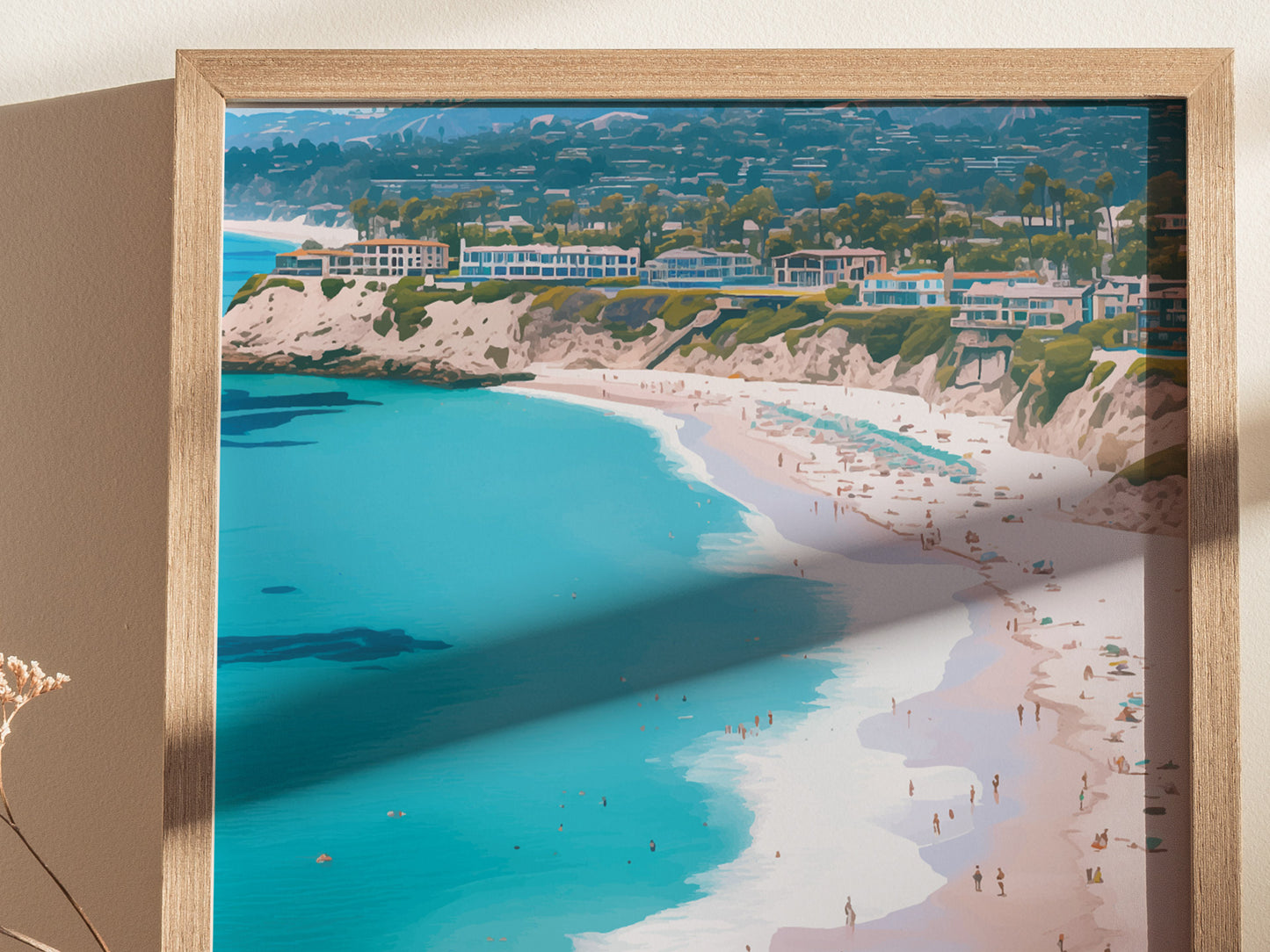 A framed poster depicting a vibrant coastal scene with turquoise waters, sandy beaches, and cliffside homes under a clear blue sky, casting shadows on the wall.