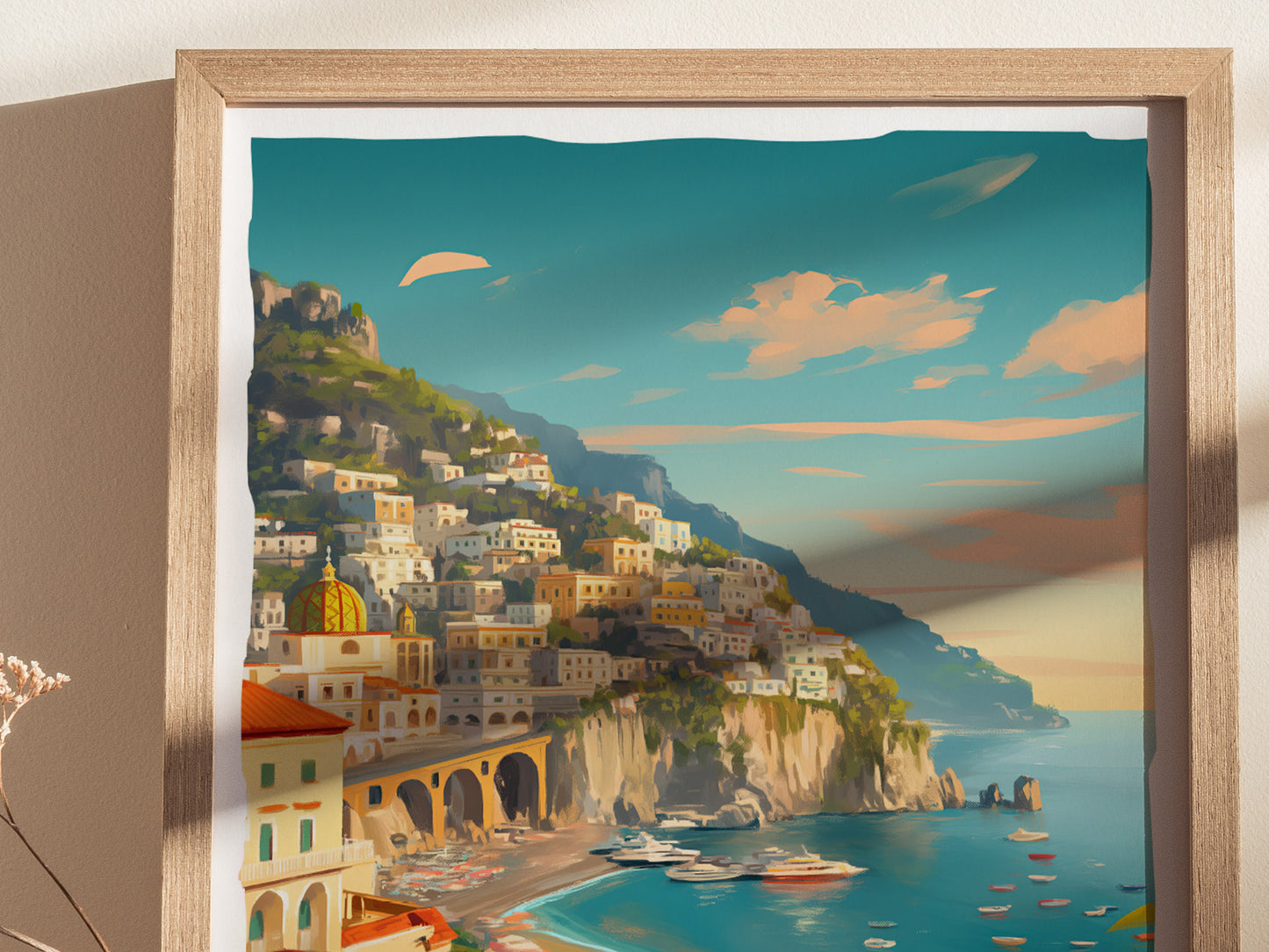 A framed artwork depicting the Amalfi Coast, with pastel-colored buildings on steep cliffs above a turquoise sea under a vibrant sky. Boats are visible in the water below.