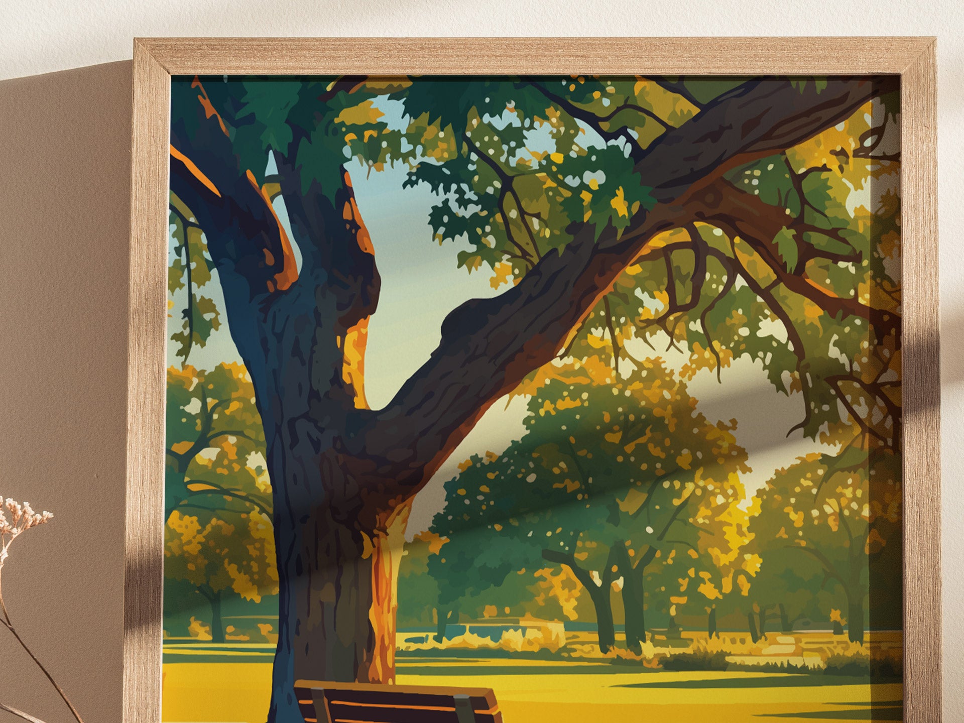 Framed artwork depicting a sunlit park scene with a large tree, vibrant green and yellow foliage, and a wooden bench. The print is set against a neutral wall background.