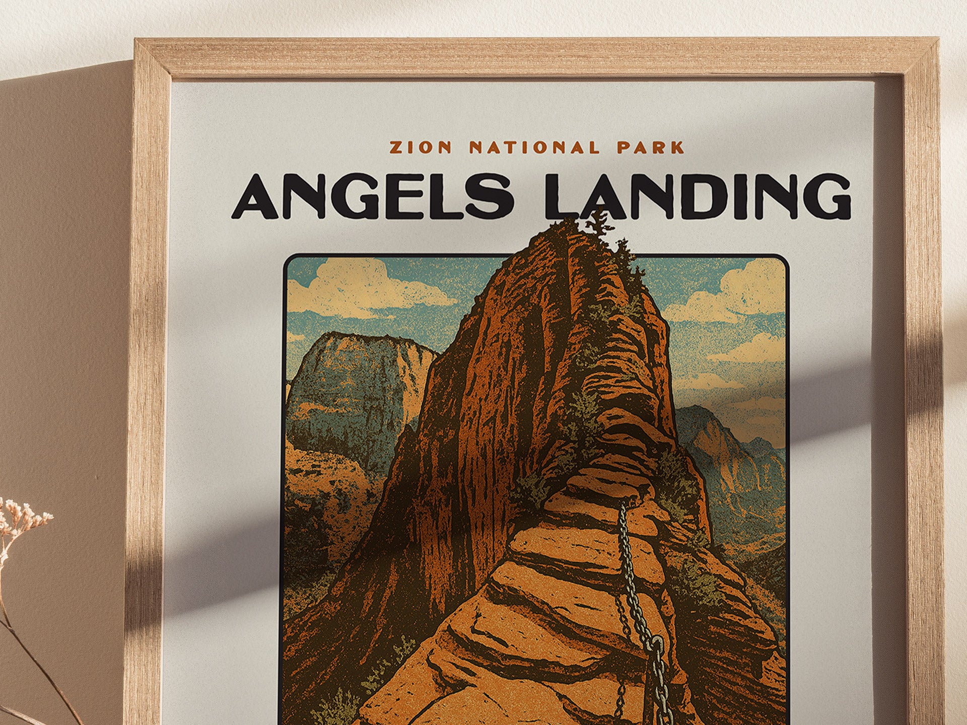 A framed vintage-style poster of Angels Landing in Zion National Park, featuring a steep sandstone ridge and canyon walls under a blue sky.