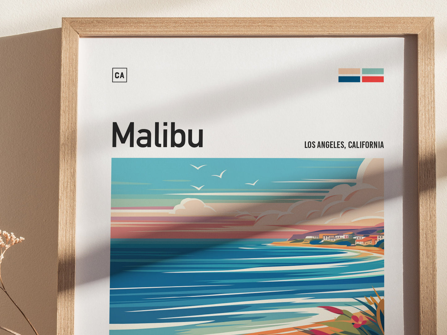 A framed poster featuring an abstract depiction of Malibus coastline with vibrant colors, ocean waves, and birds in the sky. The text reads Malibu, Los Angeles, California.