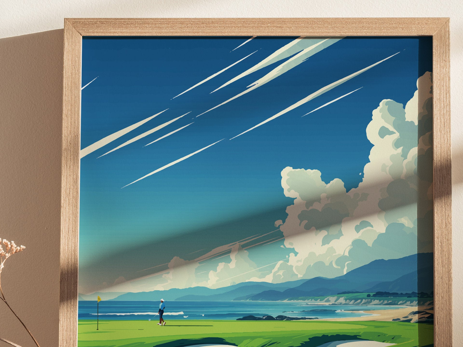 A framed poster depicts a golfer on a vibrant green course beside the ocean, with dramatic clouds and streaked sky above, conveying a serene coastal landscape.