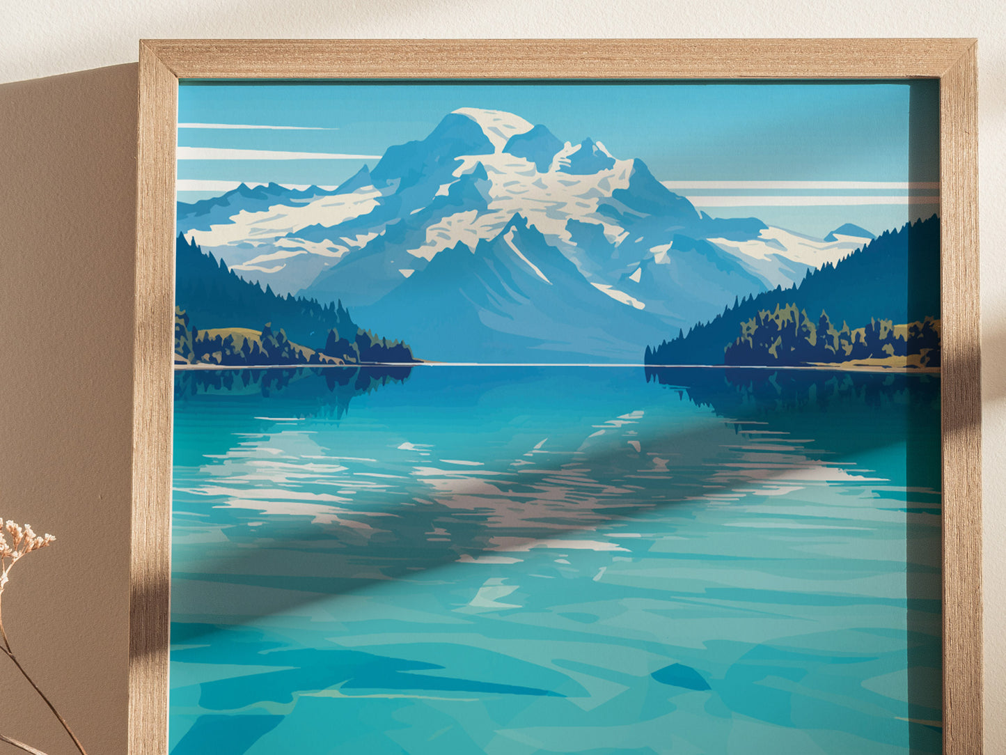 A framed poster depicting a serene lake with turquoise waters, surrounded by lush forests and majestic snow-capped mountains under a clear blue sky.
