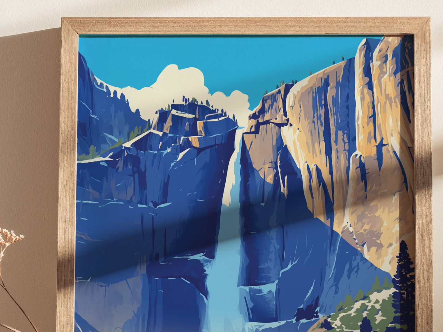 A framed poster depicts a stylized illustration of Upper Yosemite Falls with vibrant blue and orange hues, capturing the waterfall cascading down rocky cliffs under a bright sky.