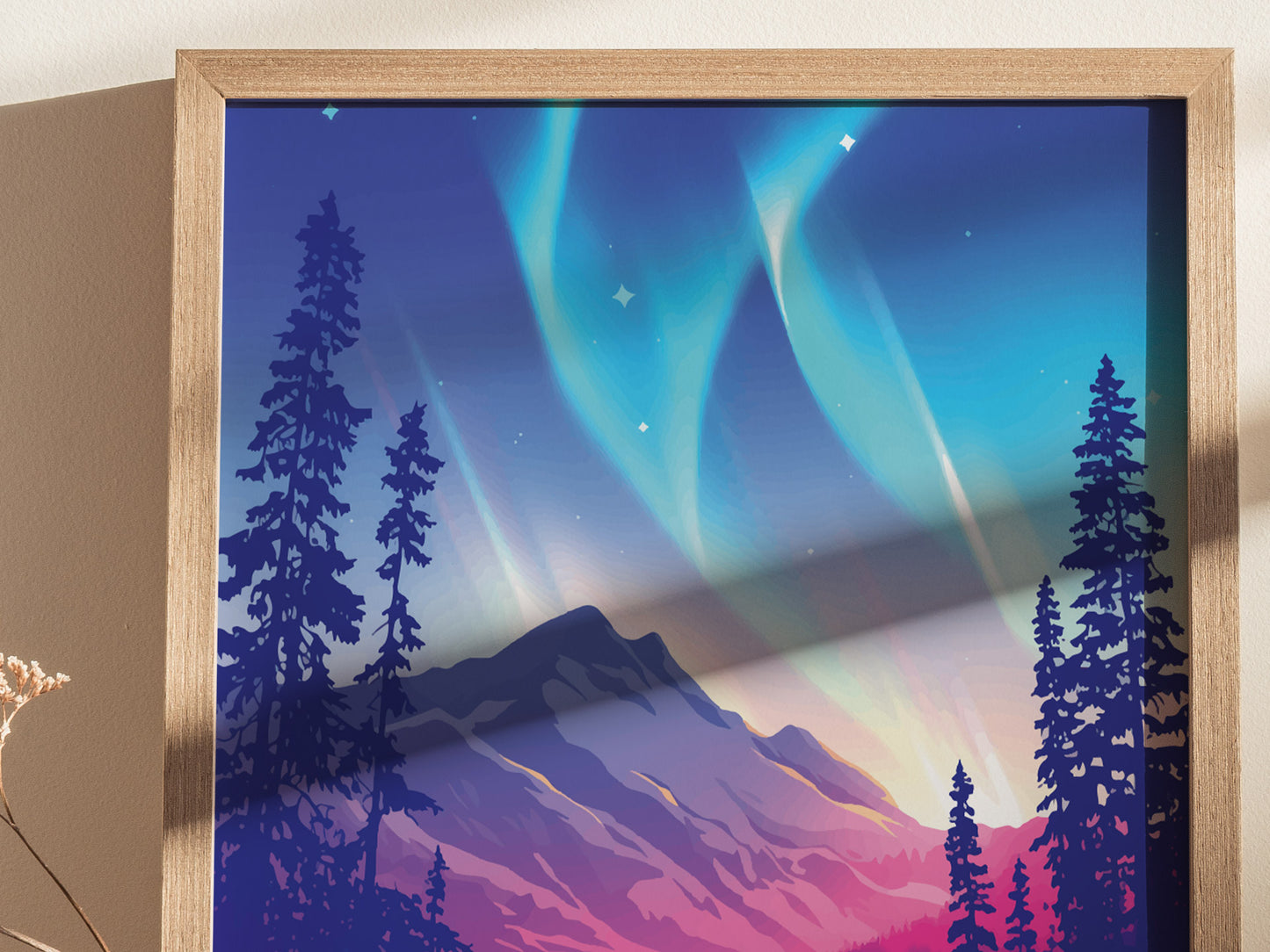 Framed artwork depicting the Northern Lights with vibrant green and blue hues over silhouetted pine trees and a mountainous landscape. The poster is presented in a light wooden frame.