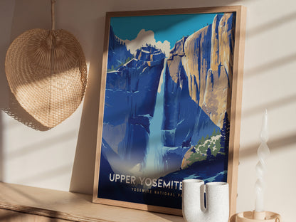 A framed poster of Upper Yosemite Falls features a stylized depiction of the waterfall against granite cliffs. Its displayed on a wooden surface with a woven fan and a twisted.
