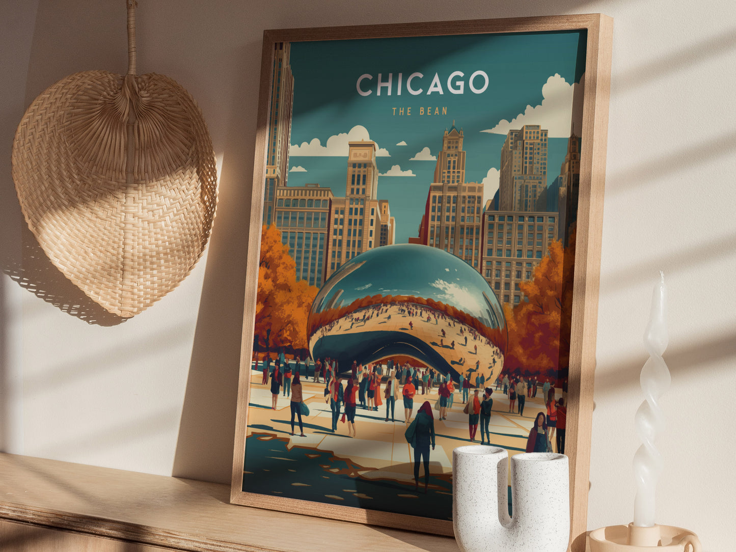 A framed poster of the Chicago Bean in Millennium Park is displayed on a wooden shelf, surrounded by a woven wall decor and a twisted candle.