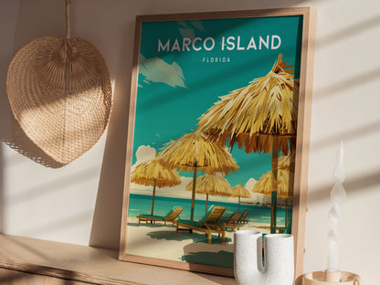 A framed poster of Marco Island, Florida, featuring beach chairs under straw umbrellas, is displayed against a wall with a woven basket and decorative candle nearby.