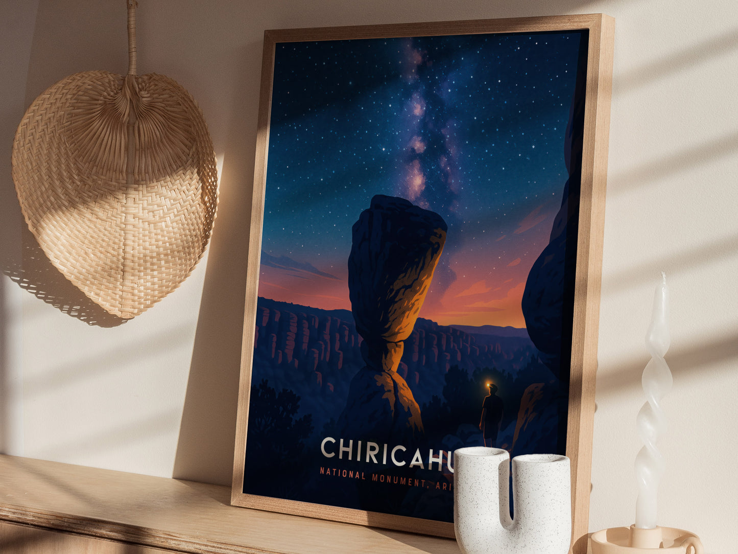 A framed poster of Chiricahua National Monument features a striking night scene with a starry sky and a silhouette of a towering rock formation.