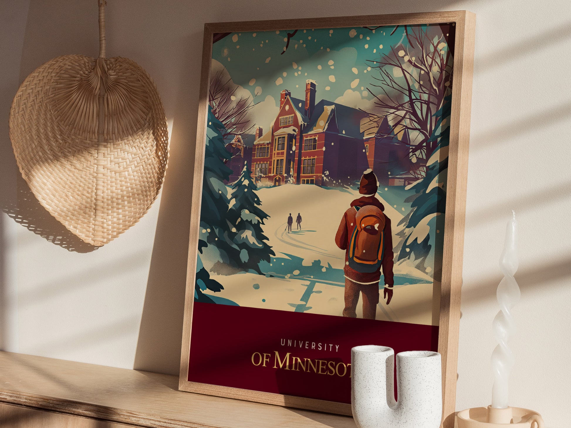 A framed University of Minnesota poster depicts a snowy campus scene with a student in a red jacket. Nearby, a woven wall decoration and candle are visible.