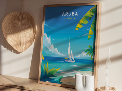 A framed Aruba travel poster featuring a sailboat on turquoise waters and palm leaves, displayed on a shelf with a woven wall hanging and decorative candle.