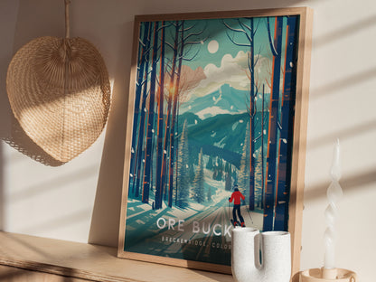 A framed poster showing a skier in a red jacket navigating through a snowy forest under a full moon. The poster is displayed on a shelf next to woven decor.