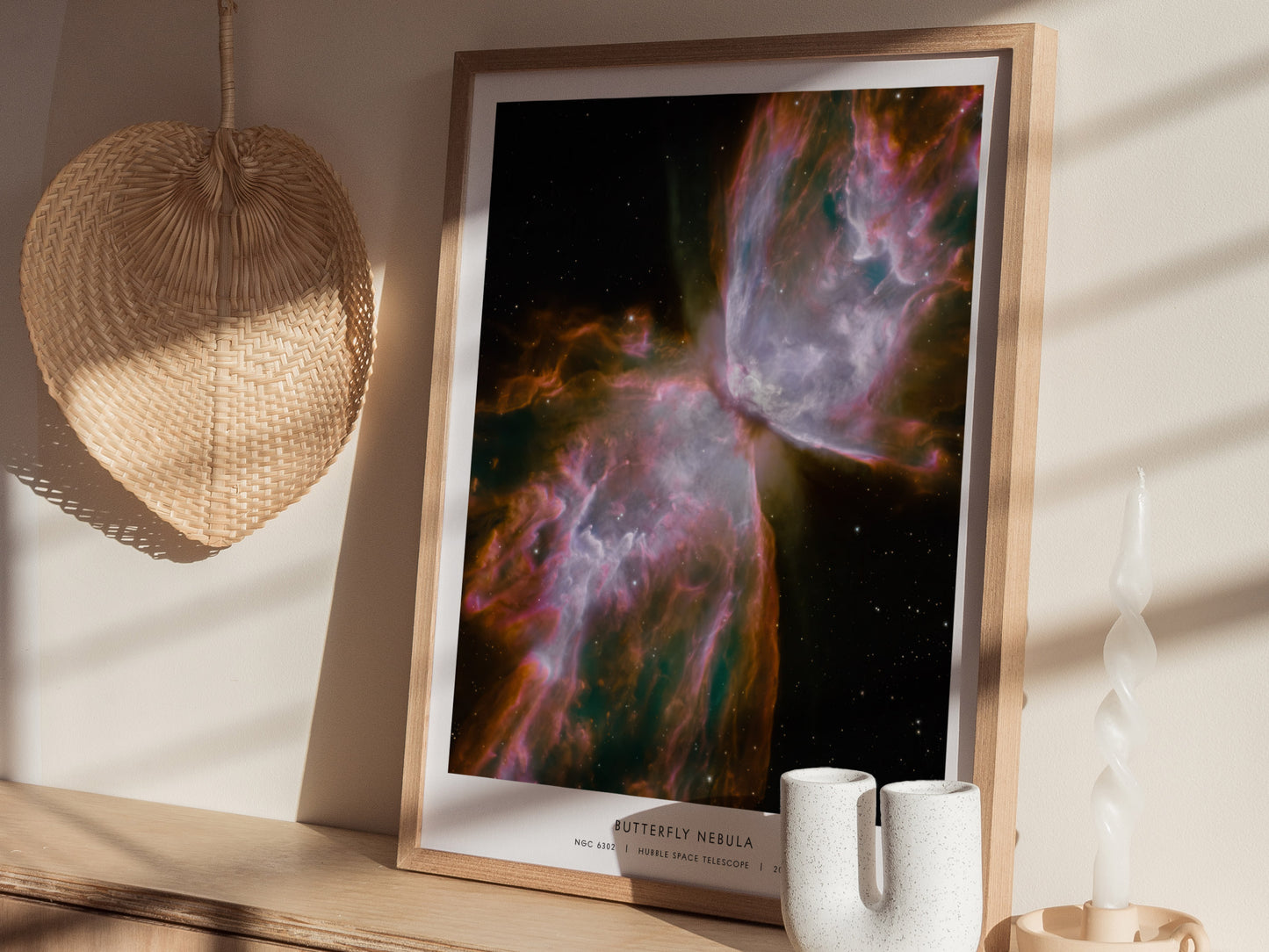 A beautifully framed poster of the Butterfly Nebula, showcasing vibrant colors of pink, purple, and orange swirling against a dark cosmic background.