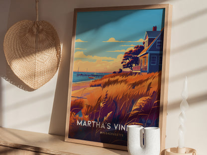 A framed poster of Marthas Vineyard is displayed on a wooden shelf, featuring a coastal scene with a house, grasses, and the ocean. A woven straw decoration hangs nearby.