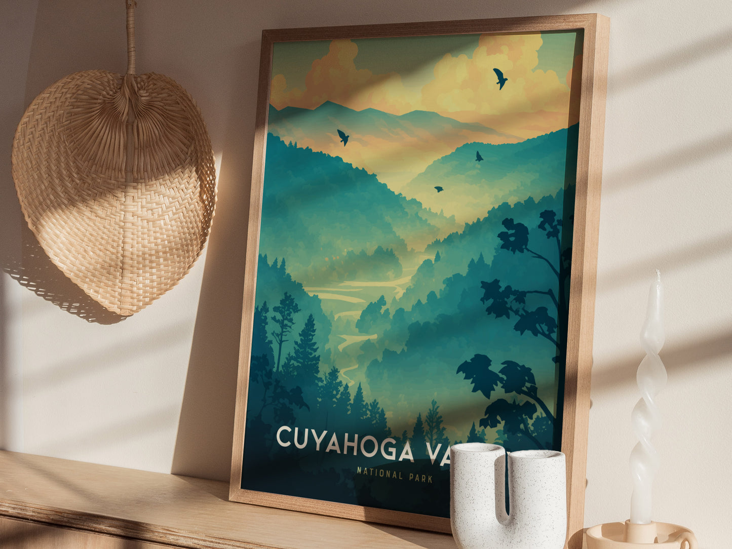 A framed poster of Cuyahoga Valley National Park features a serene landscape of rolling hills and forests, with birds silhouetted against a colorful sky.