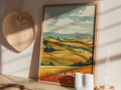 A framed poster depicting colorful rolling hills and vineyards rests on a wooden surface, next to a woven wall decoration and a twisted candle.