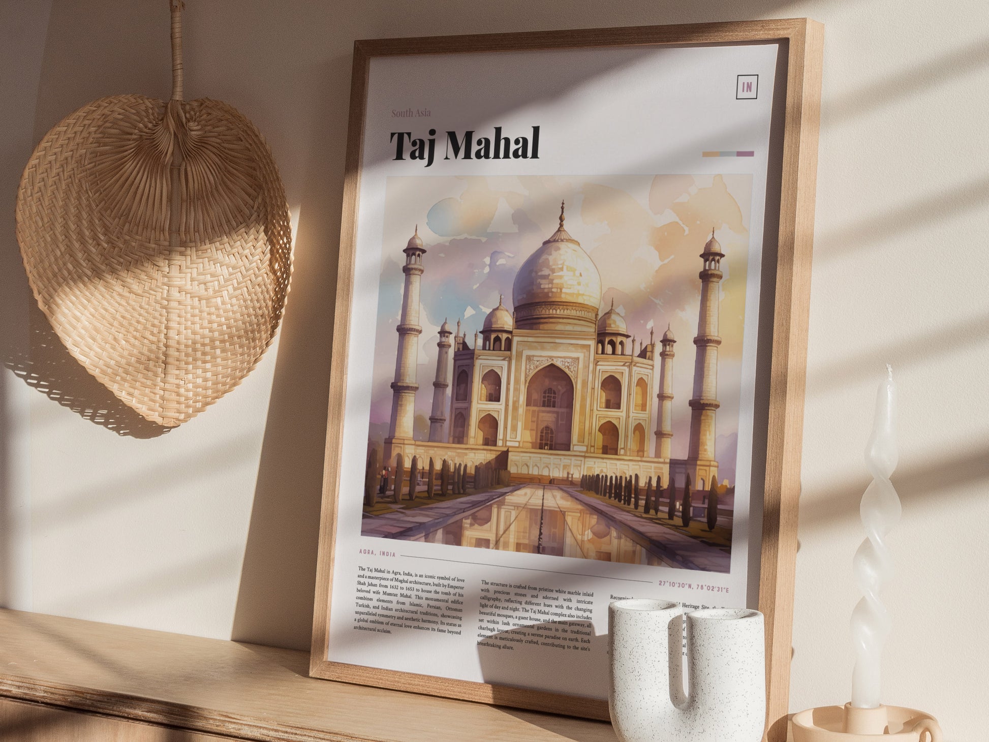 A framed Taj Mahal poster featuring a watercolor illustration is displayed on a shelf. Nearby, a woven basket decor and a twisted white candle add to the aesthetic.