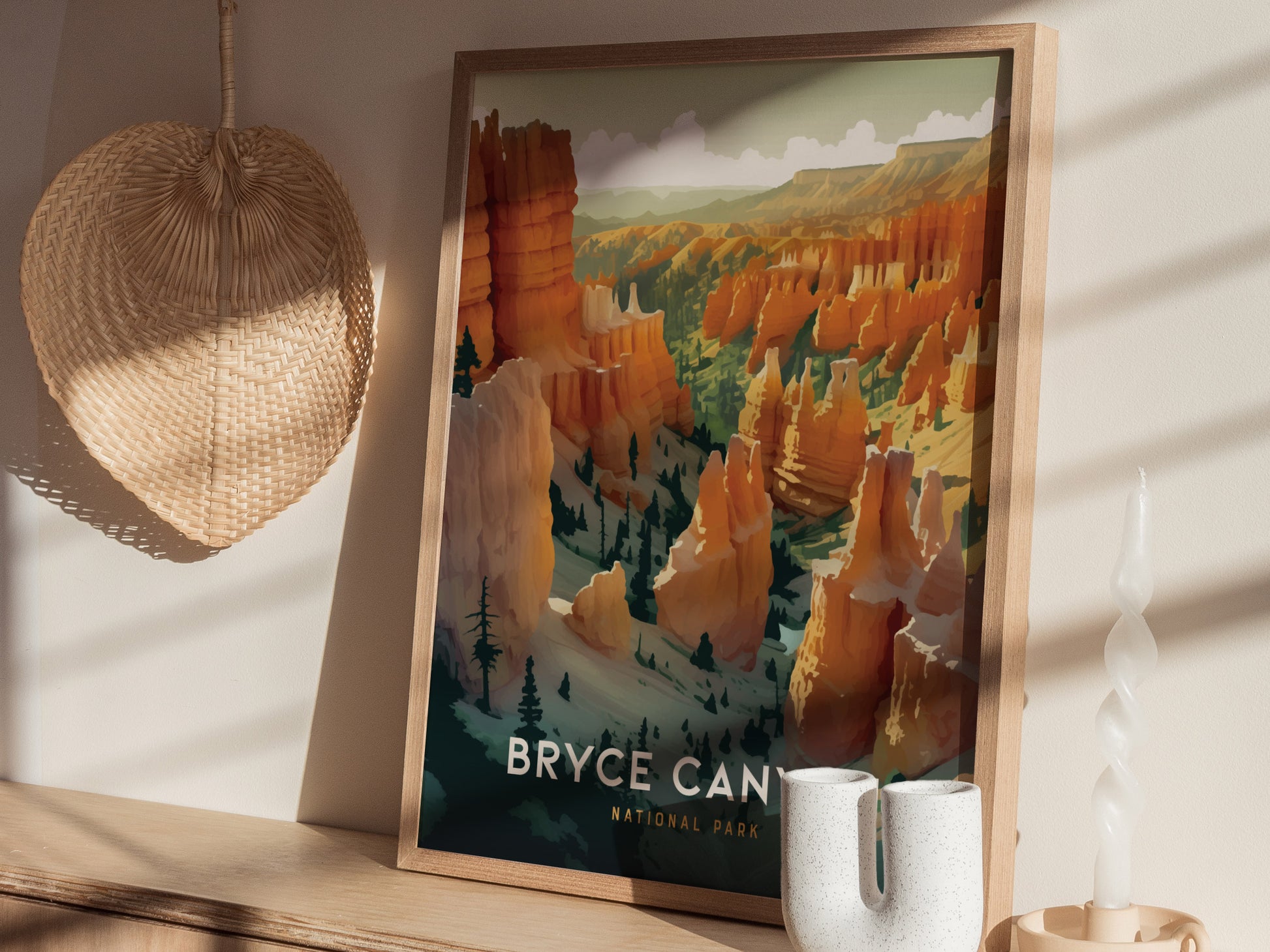 A framed print of Bryce Canyon National Park features vibrant hoodoos in warm tones, sitting on a wooden shelf with a woven basket and candle nearby.