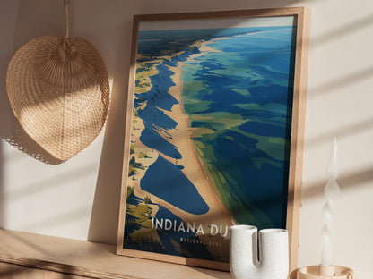 A framed poster of Indiana Dunes National Park featuring a stylized view of the shoreline is displayed on a wooden surface, next to a woven decorative piece and a twisted.