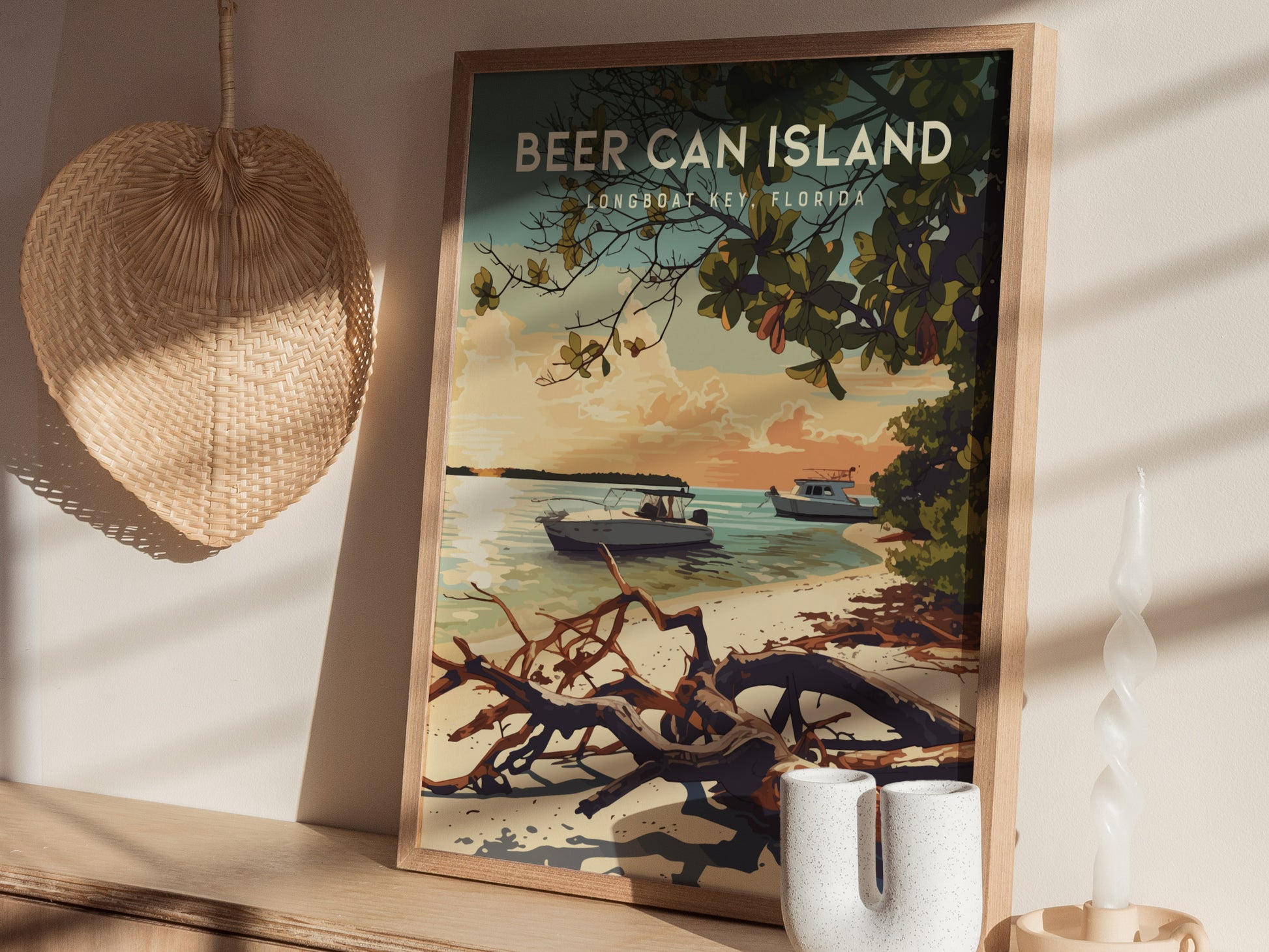 A framed poster of Beer Can Island, Longboat Key, Florida, sits on a wooden surface, depicting boats on tranquil waters near a sandy beach with driftwood and trees. The scene is set in a warm, tropical sunset atmosphere.