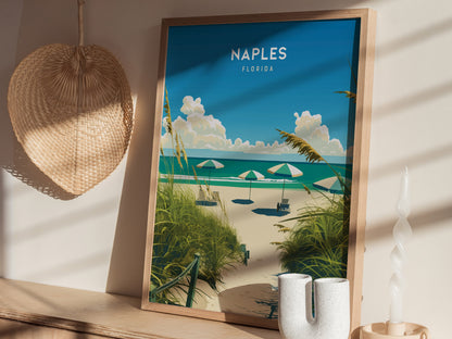 A framed poster of a beach scene with umbrellas is displayed on a shelf, accompanied by a woven fan, a candle, and decorative vases. Sunlight casts soft shadows.