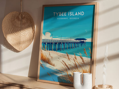 A framed Tybee Island poster depicting a pier and sandy dunes is placed on a wooden shelf, alongside a woven fan and decorative vases.