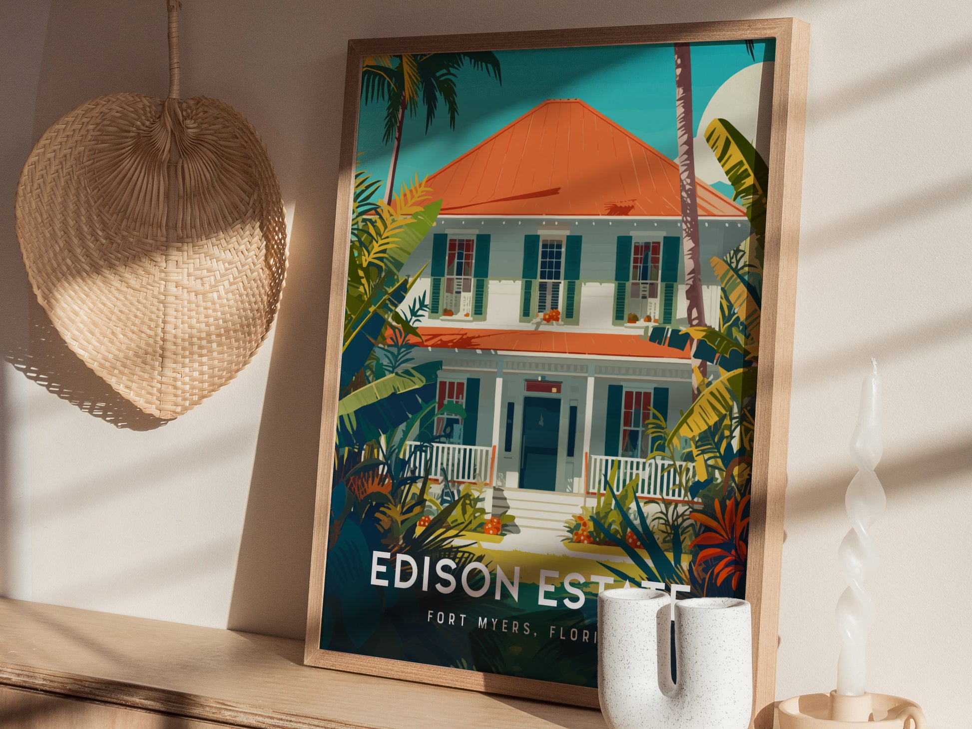 A framed poster of a colorful house surrounded by lush greenery is displayed on a wooden shelf. A woven decorative piece hangs on the wall beside it.