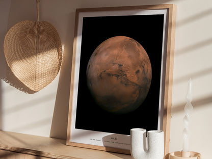 Framed poster of Mars on a wall with a lamp and decor items.
