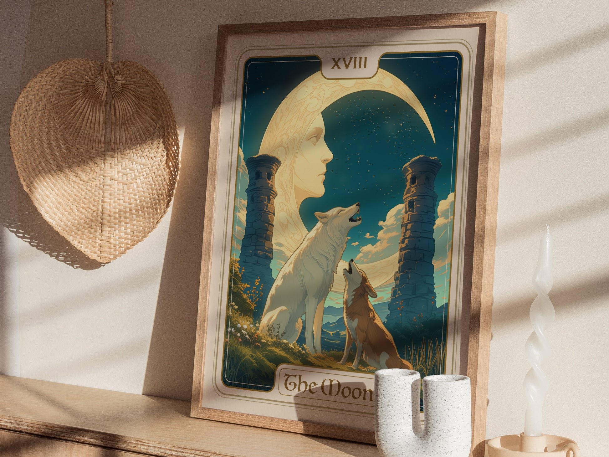 A framed tarot poster depicting a crescent moon with a face, two howling wolves, ancient pillars, and a starry sky, displayed on a wooden surface.