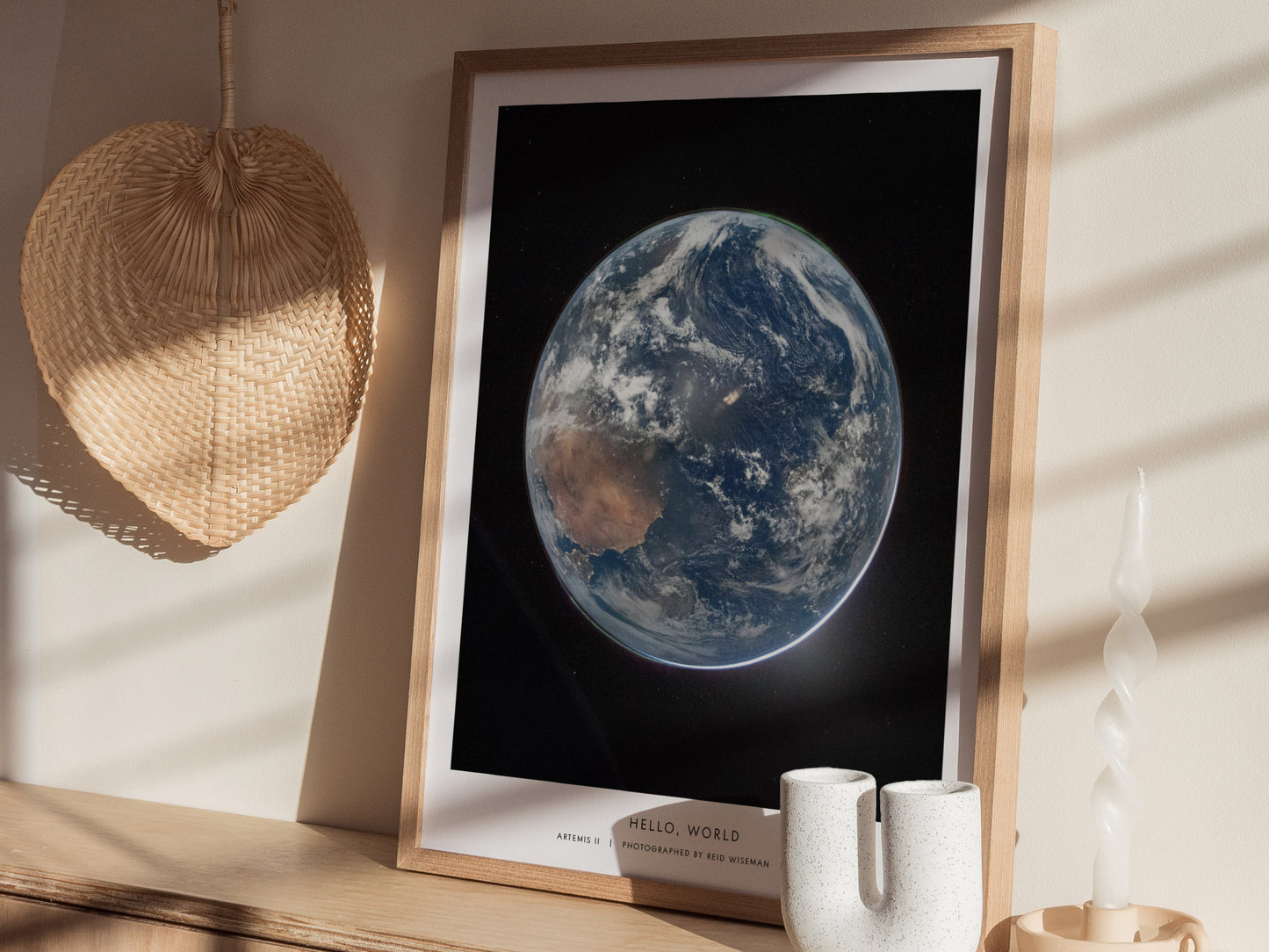 A framed poster featuring a stunning view of Earth from space, showcasing its blue oceans and white clouds against a dark backdrop.