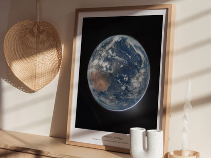 A framed poster featuring a stunning view of Earth from space, showcasing its blue oceans and white clouds against a dark backdrop.