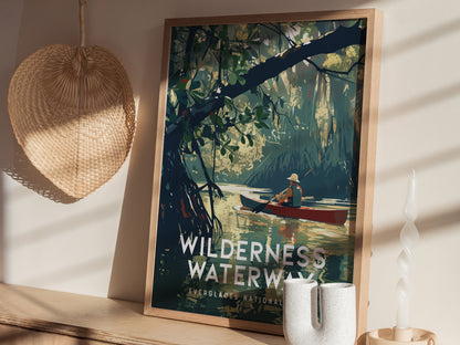 A framed poster of a canoeist navigating calm waters in a lush mangrove forest is displayed on a shelf, accompanied by a woven basket and a twisted candle.