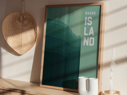 A framed poster with Rhode Island text in bold letters is displayed on a wooden shelf, accompanied by a wicker wall decoration and a white ceramic vase.