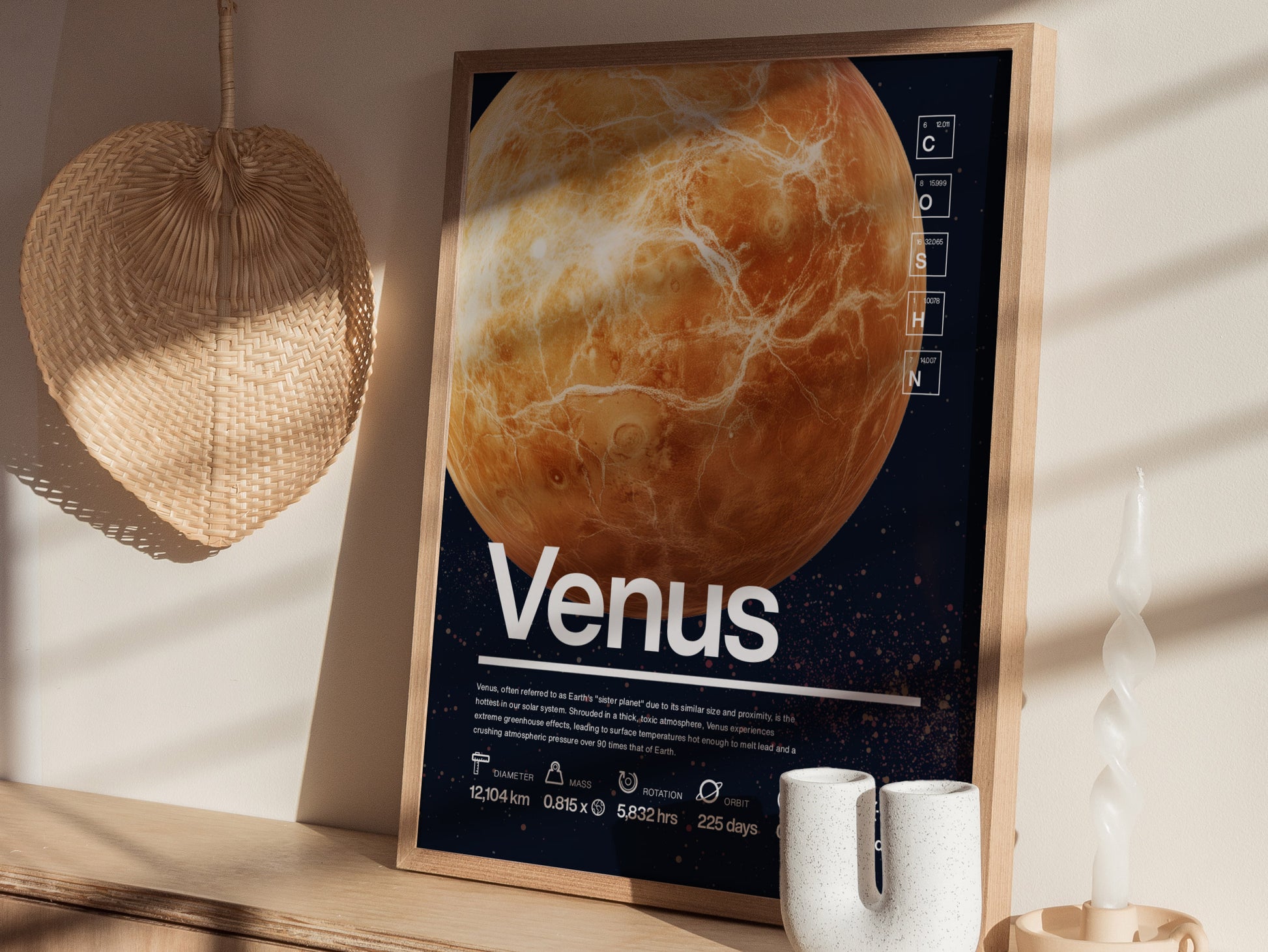 A framed Venus planet poster with scientific data in Helvetica typography is displayed on a shelf, accompanied by a woven basket and decorative candle.