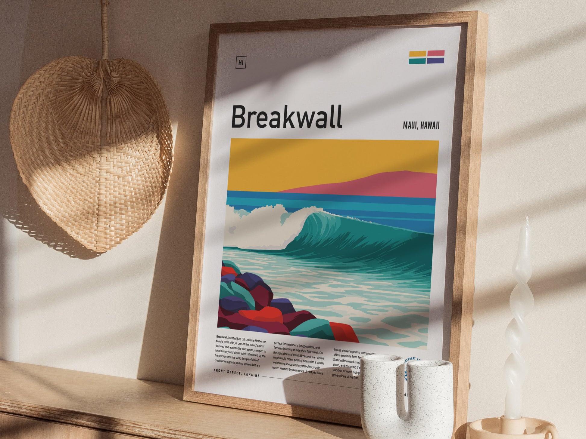 A framed poster titled Breakwall showcases a vibrant illustration of a wave crashing against colorful rocks, set against a serene landscape with rolling hills and a pastel sky.