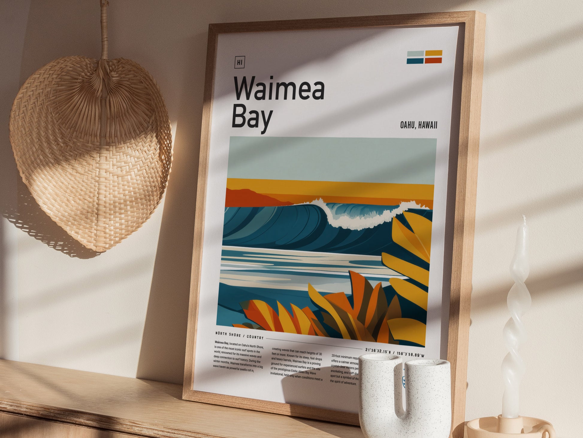A framed Waimea Bay poster featuring vibrant waves and tropical foliage is displayed on a wooden surface. A woven wall decor and a twisted candle are nearby, illuminated by soft.