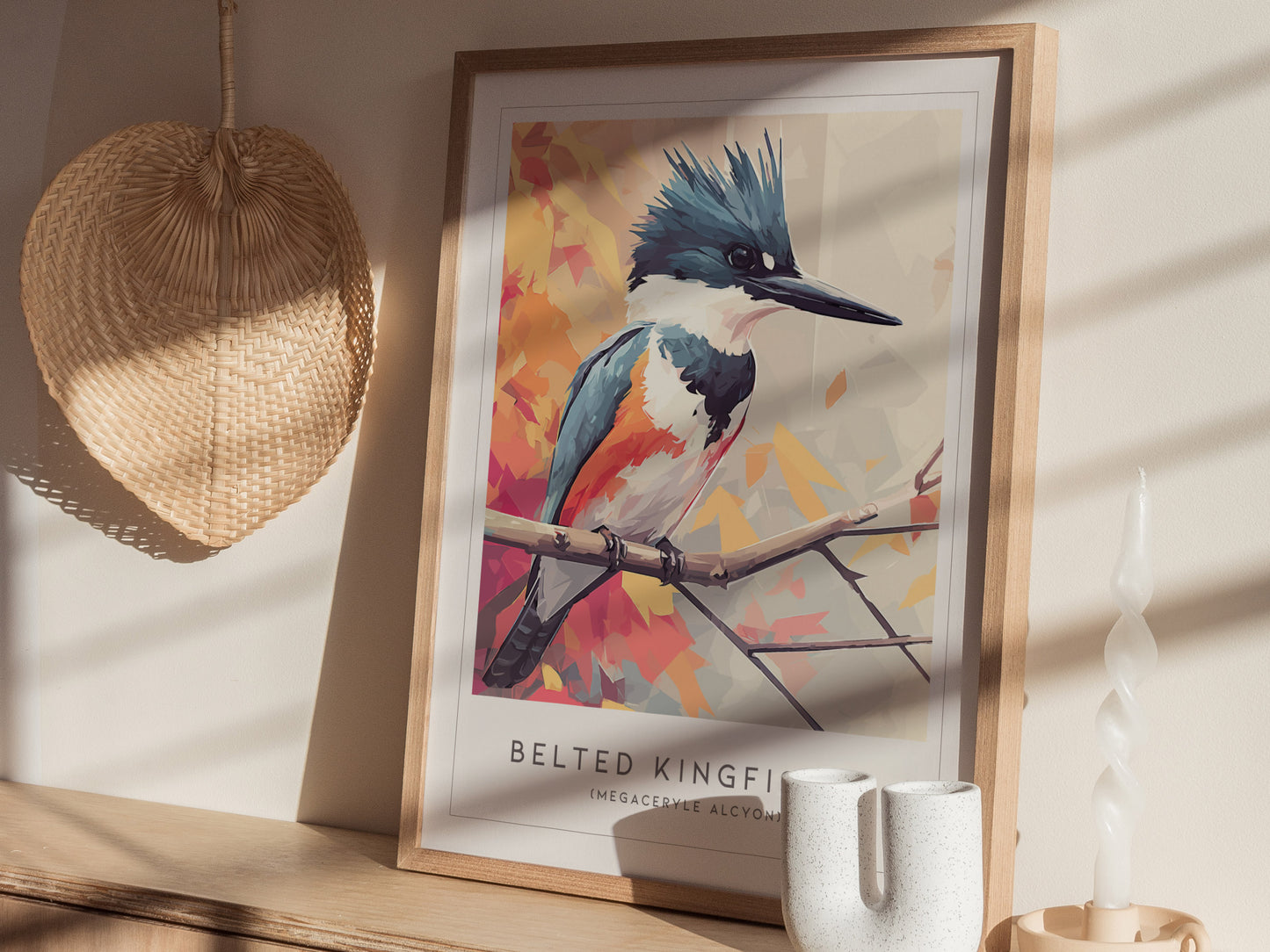 A framed art print of a Belted Kingfisher, showcasing its vibrant blue and white plumage, is displayed against a light-colored wall.