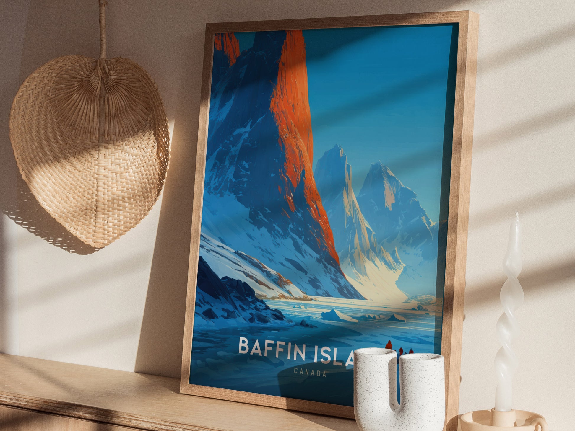 A framed poster of Baffin Island in Canada displays stunning mountains with vibrant blue and orange hues, set against a serene icy landscape.