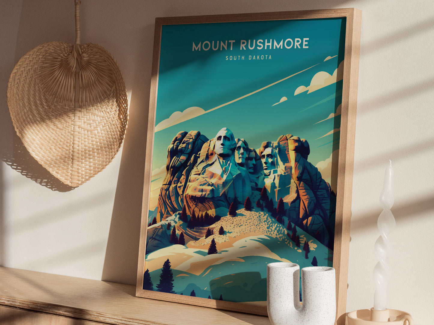 A framed Mount Rushmore poster with a vibrant, artistic depiction of the monument is displayed on a wooden shelf alongside a woven basket and a twisted candle.