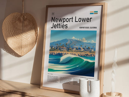 A framed Newport Lower Jetties poster featuring a coastal scene with waves and mountains is displayed on a wooden shelf alongside a woven basket and a twisted candle.